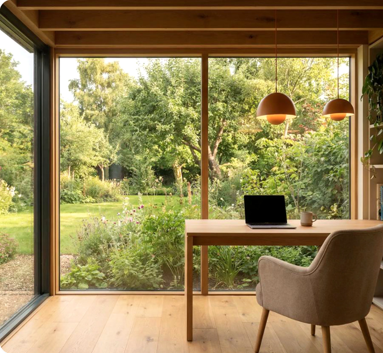 Oak desk and armchair facing full-height glazing onto a planted garden